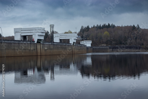 Lake Eupen (Lac d'Eupen) as it reaches the Eupen Dam, also known as Barrage de la Vesdre, (Wesertalsperre) near Eupen, Belgium, on a overcast moody winter day. Copy space above and below.