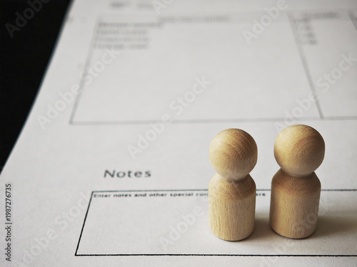 Wooden figures stand on notes for financial planning and money management