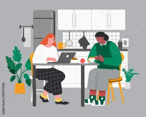 Two women enjoy breakfast and work in a modern kitchen setting