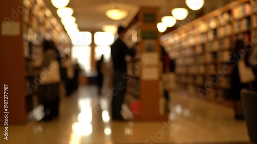 Blurred view of people browsing books in a quiet library or bookstore.