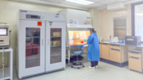 Blur background Laboratory technician working in biosafety cabinet inside lab, sterile technique, scientific equipment, refrigerators, controlled environment for microbiology and medical research.