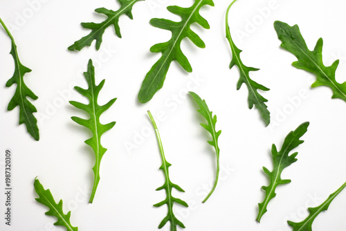 Arugula leaves on white background, fresh green salad, healthy food flat lay with copy space