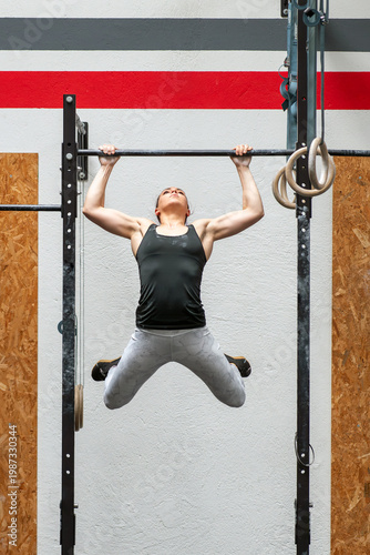 Wallpaper Mural Female athlete performing kipping pull up exercise in gym Torontodigital.ca