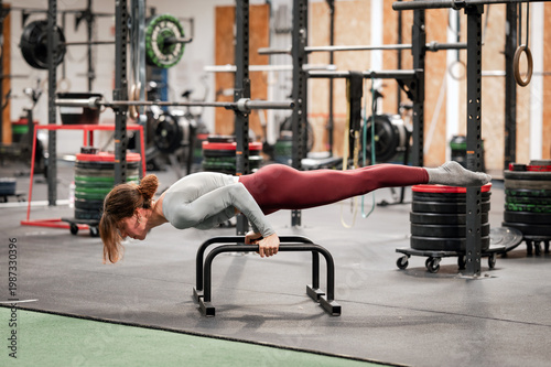 Wallpaper Mural Woman holding advanced calisthenics planche on parallettes in gym Torontodigital.ca