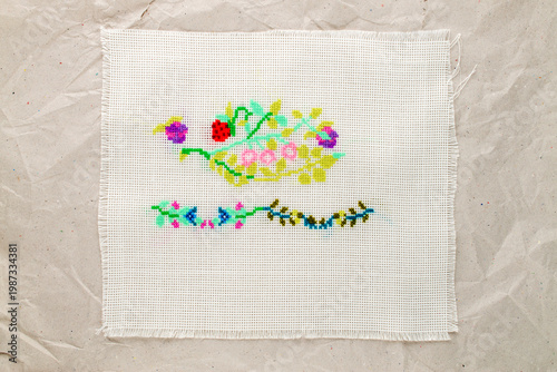 Quadro su tela Cross-stitch embroidery on light fabric, macro, top view.