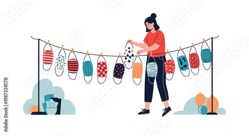 Woman hangs a variety of colorful and patterned reusable face masks on a clothesline outdoors to dry after washing for reuse.