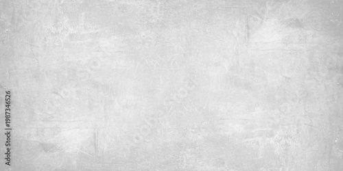 A dark grey brushed metal texture with a grunge pattern on an old rough surface creates a vintage aged backdrop for a textured industrial design. Light gray concrete wall texture background