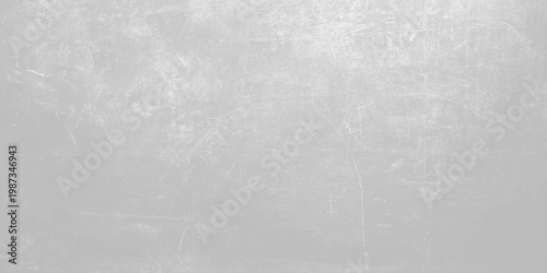 A dark grey brushed metal texture with a grunge pattern on an old rough surface creates a vintage aged backdrop for a textured industrial design. Light gray concrete wall texture background