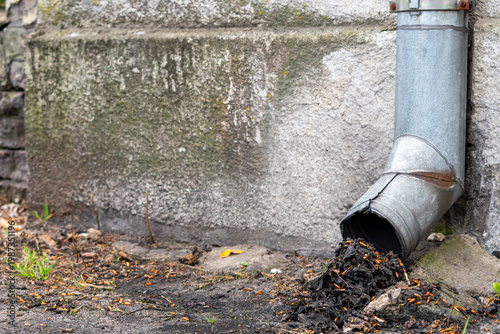 Принти на полотні Clogged downspout full of dry leaves and debris against an old concrete wall