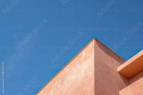Obraz Abstract geometry of a peach-colored building against a bright sky