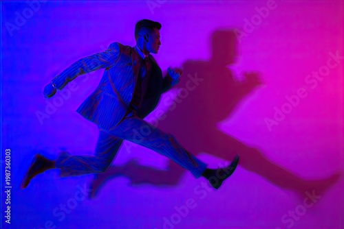 Dynamic pose of a man in a pinstripe suit against a vibrant pink and blue backdrop