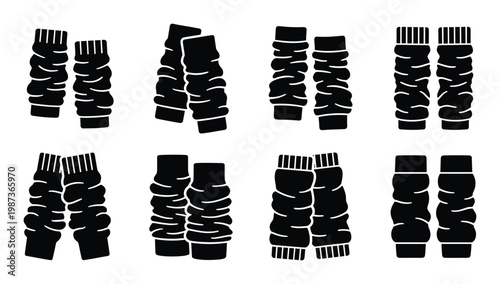 Eight pairs of black leg warmers with ribbed texture and contrasting trim on transparent background