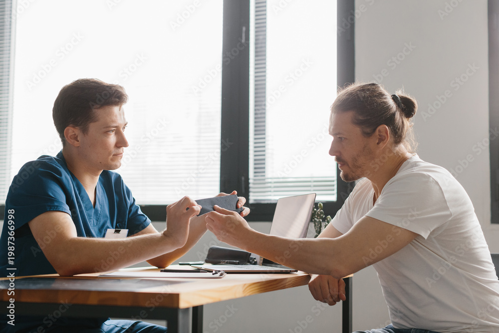 Obraz premium Orthopedic doctor assessing treatment options for a patient during a consultation.