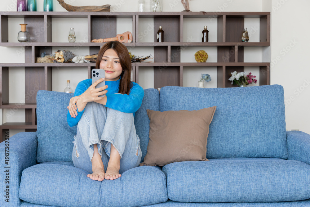 Obraz premium 部屋でスマホを見る女性