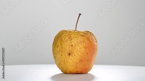 Wallpaper Mural Dehydrated and wrinkled yellow apple rotating in slow motion, isolated on a white background Torontodigital.ca