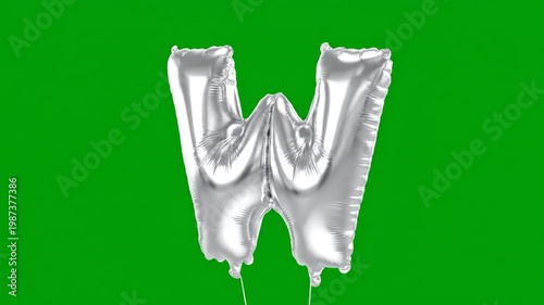 Silver Foil Balloon in the Shape of the Letter W Against a Green Background, Perfect for Celebrations