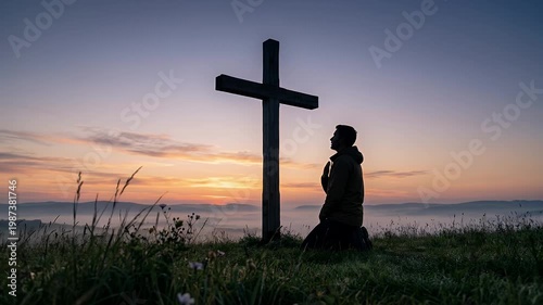 Man Praying in Front of a Large Cross at Sunrise