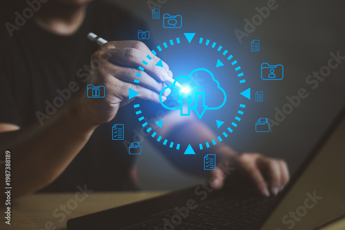 Professional man using stylus for cloud data backup and file sync with advanced holographic interface on laptop