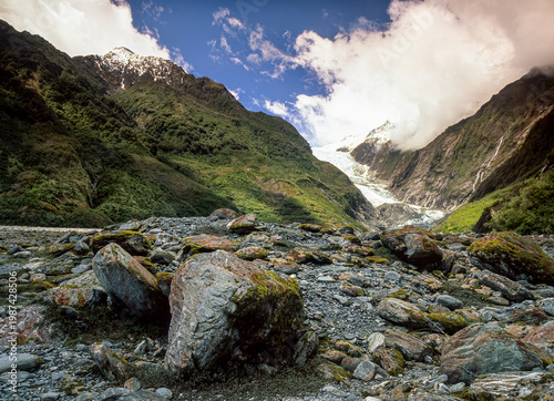 Boulder field left behind by the retreat of the Franz Josef Glacier (in background) on the South Island of New Zealand. Glacier is retreating because of climate change.