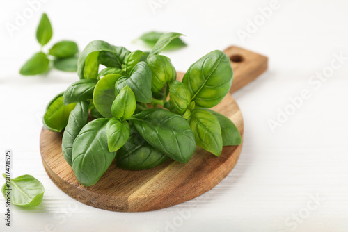 Fresh basil leaves on white wooden table, closeup