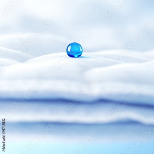 Crystal clear water droplet on soft white fabric surface