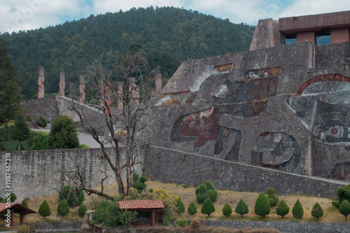 Monumental stone wall with artistic reliefs of abstract figures and animals in an archaeological zone