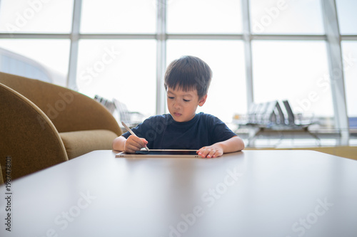Young Boy Engaged in Drawing at Airport Lounge with Modern Design