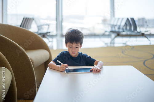 Young Boy Engaged in Creative Drawing at Airport Lounge with Modern Design