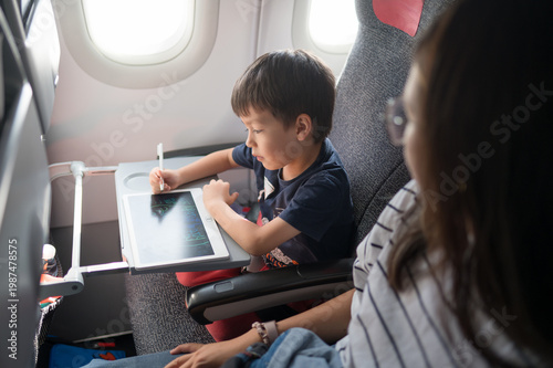 Young Boy Engaged in Creative Drawing on Tablet While Traveling in Airplane