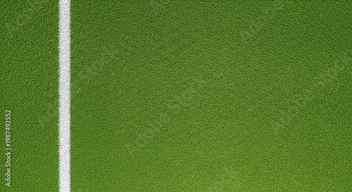 A vibrant green patch of textured artificial grass surface featuring a single straight white painted line running vertically down the left side representing a sports field boundary or marking area