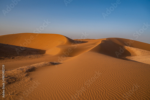 Minimal desert landscape featuring smooth sand dunes and soft natural light. Clean and calm composition with large copy space, ideal for backgrounds, travel concepts, nature themes,