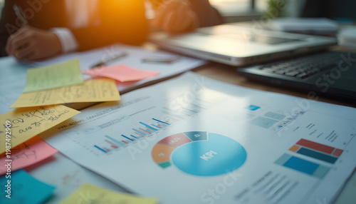 Business documents with KPI charts and colorful sticky notes on