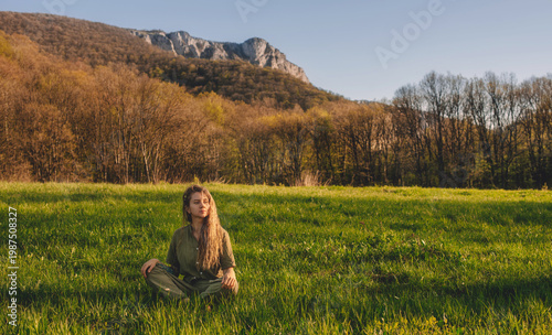 Woman Meditating in Green Meadow with Mountain View