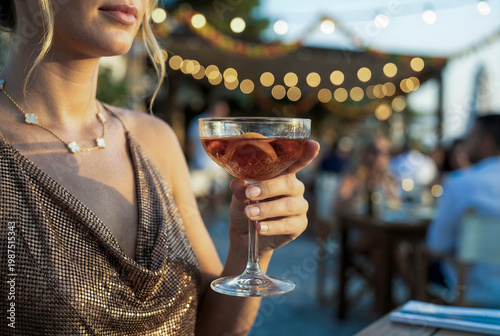Woman holding cocktail celebrating summer evening party