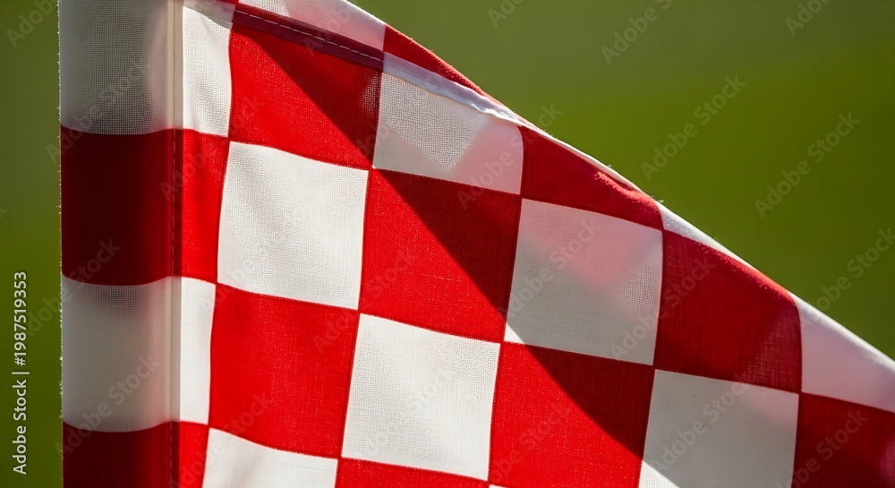 Fototapeta premium Close-up of a red and white checkered flag waving gently in the wind