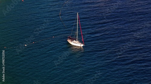Aerial view of a white sailboat anchored in the deep blue waters of the Adriatic Sea, Dalmatian Coast, Croatia