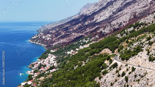 Aerial view of Pisak village on the Makarska Riviera coastline with Biokovo mountains and the Adriatic Sea in Croatia, scenic winding road along the rocky cliffs