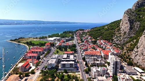 Aerial footage of Omis, Croatia, a scenic coastal town nestled between the Adriatic Sea and dramatic limestone mountains in the Dalmatia region