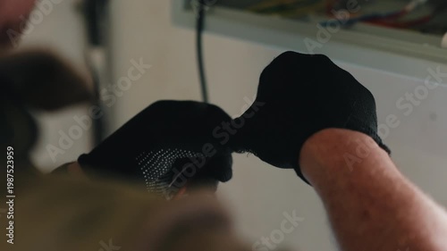 Worker stripping insulation from electrical wire close up