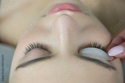 Close up of beauty model's face with perfect fresh skin and long eyelashes, lash lift laminate procedure.