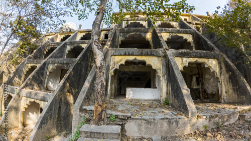 Foto Exterior view of an abandoned ashram near Rishikesh, Uttarakhand, with weathered paint, aging architecture, and surrounding trees creating a play of light and shadow in a tranquil setting