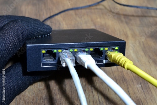 Photos Ethernet switch,network device with five ports,three of them connected with Ethernet cables