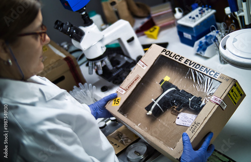 A police ballistics expert is examining the firearm involved in a homicide