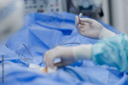 Billede på lærred Surgeon handling catheter during cardiac catheterization procedure in operating