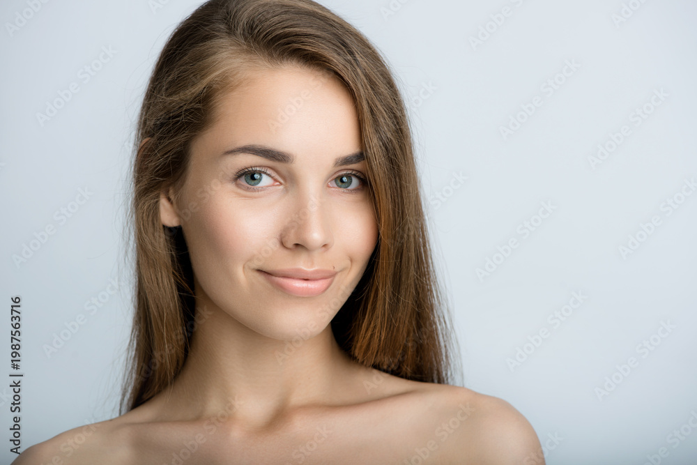 Fototapeta premium Portrait of beauty model with make-up, formed eyebrows and long eyelashes. Beautiful young smiling women face with perfect fresh skin. Spa, skincare and wellness. Selective focus. Close-up