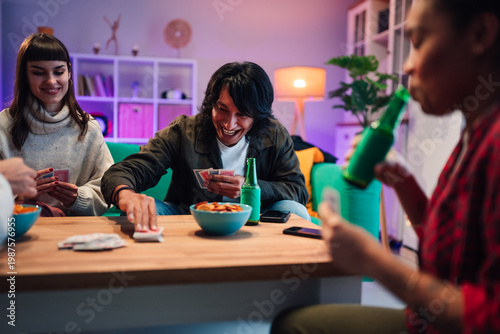 Foto Friends playing cards and laughing together, enjoying snacks and beer at a casua