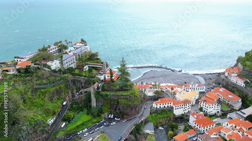 Funchal, Madeira's dramatic coastline, featuring hotels and homes perched on lush green cliffs overlooking the vibrant Atlantic Ocean. A picturesque island escape. Ponta do Sol