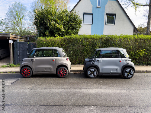 Fotografie Zwei kleine Elektroautos parken hintereinander vor einem Einfamilienhaus in Esse