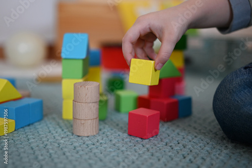 A close-up of a toddler playing with building blocks 