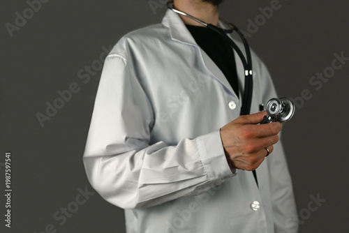 Abdoctor stands and holds a stethoscope in his right hand